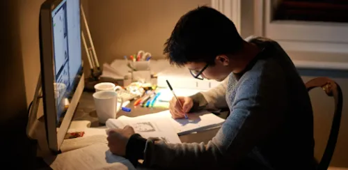 Chico estudiando con pantalla de ordenador